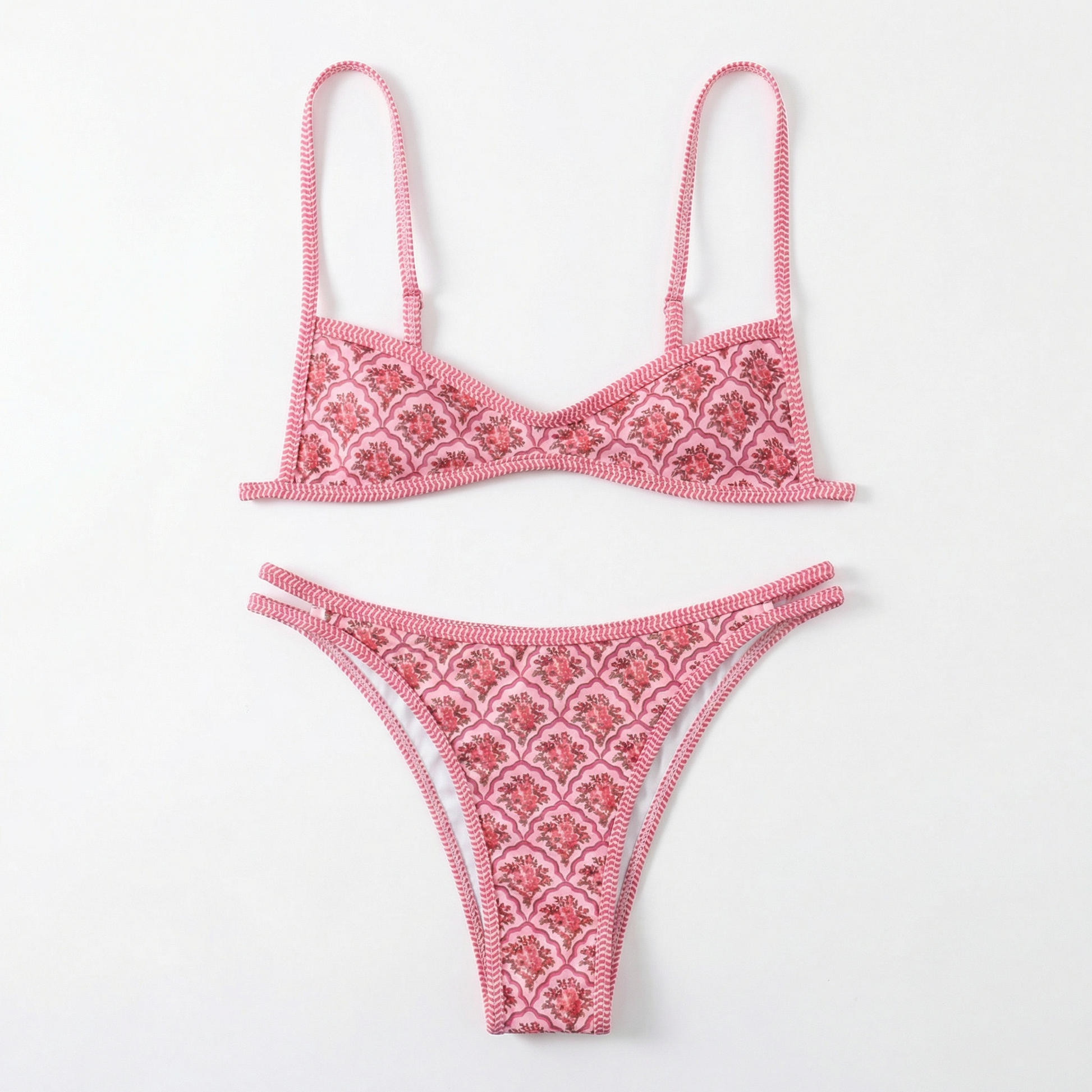 Pink bikini set with intricate patterns on a white background